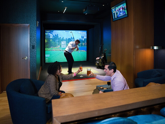 Top Golf suite with a man playing their golf VR game