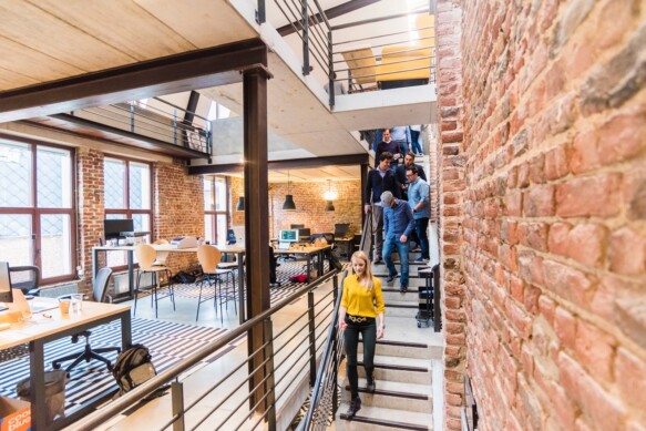 woman in yellow top walking down stairs in an office